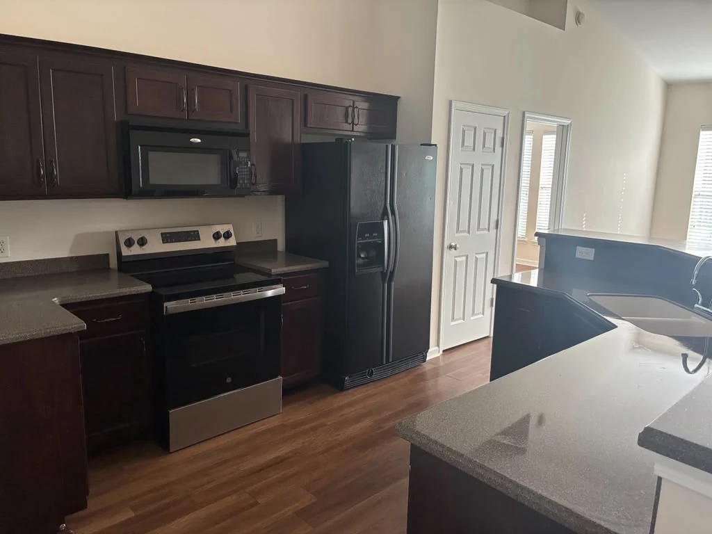 Recently refreshed kitchen with dark cabinetry and clean countertops